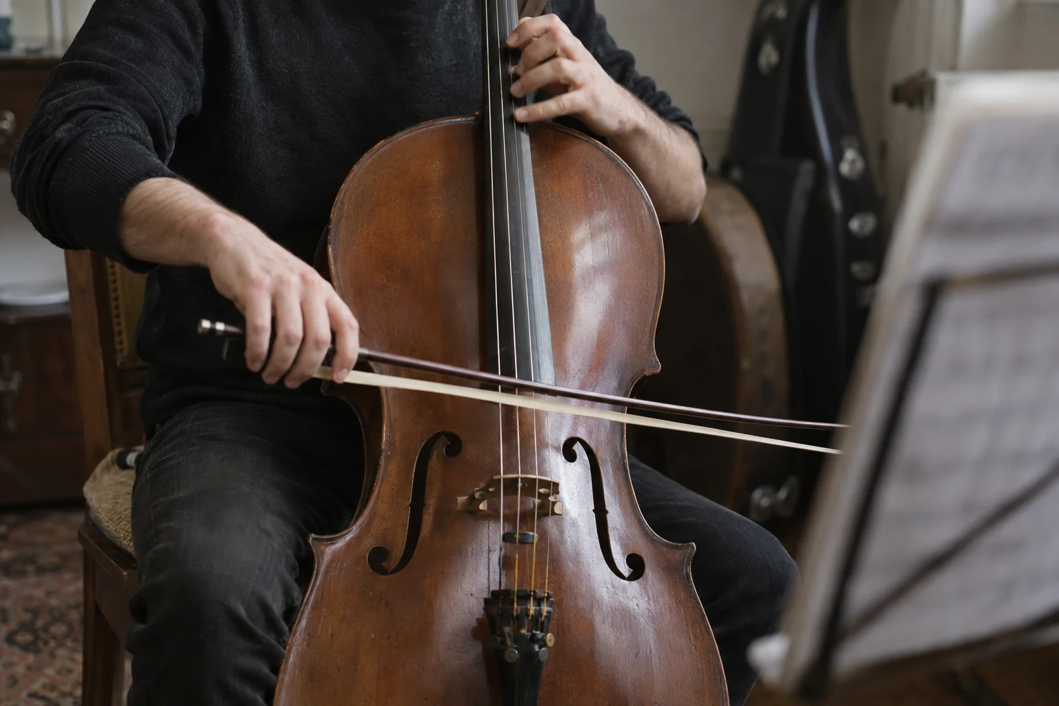 A cellist’s hands, bow, and instrument during rehearsal